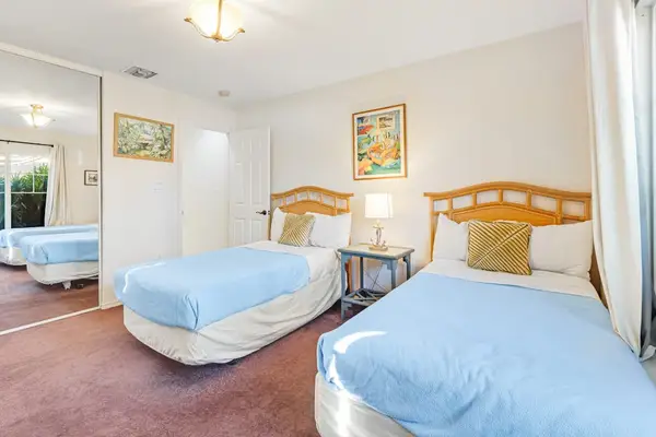 Guest room with two single beds and a flat screen tv.