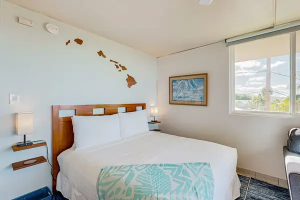 Living area featuring a Queen bed and a dresser with a television.