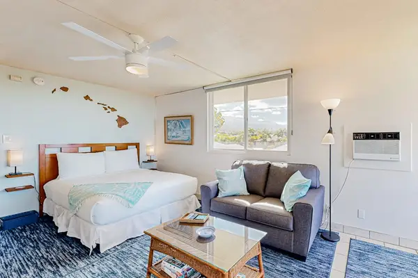 Living area featuring a Queen bed and a dresser with a television.