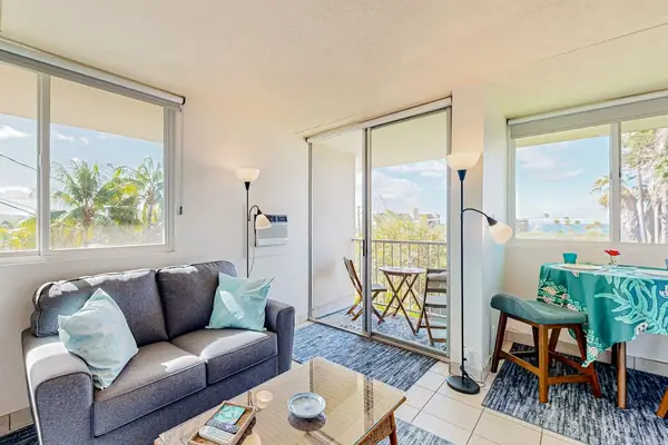 Brightly lit condo interior featuring a dining area and a sofa set next to a sliding door that opens onto a balcony.