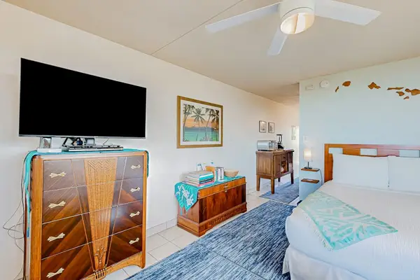 Living area featuring a Queen bed and a dresser with a television.