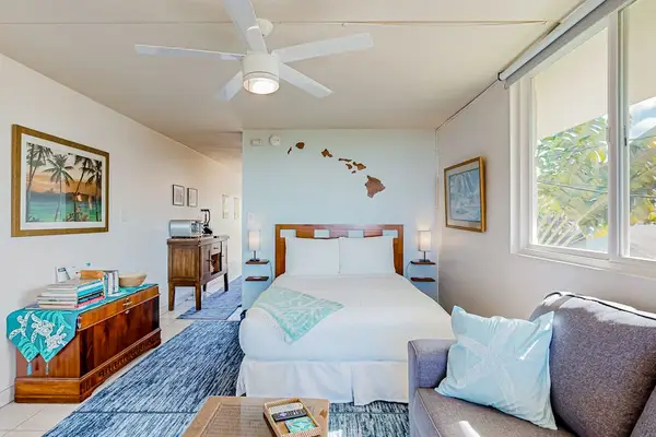 Living area featuring a Queen bed and a dresser with a television.
