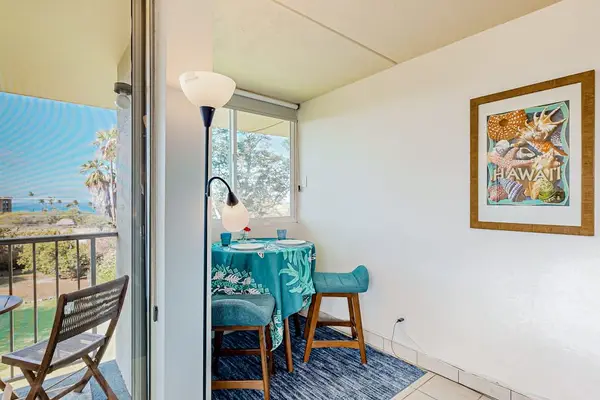 Brightly lit condo interior featuring a dining area set next to a sliding door that opens onto a balcony.