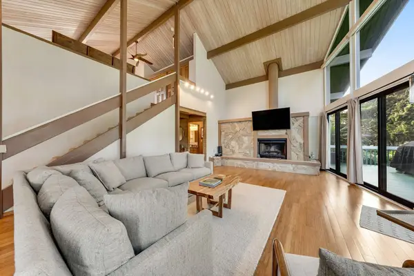 Lofty timber ceiling crowns cozy lounge with fireplace and views