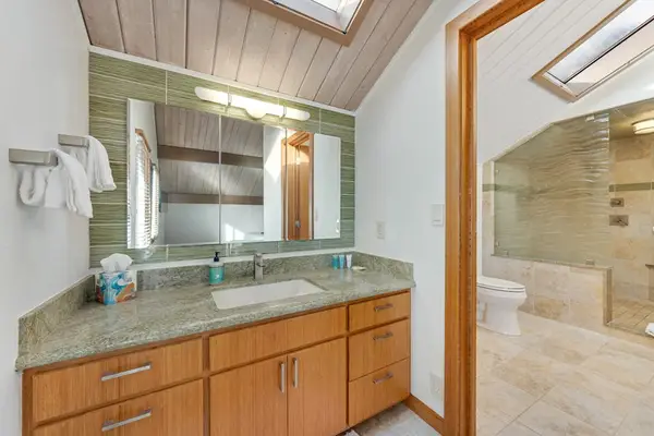 Spacious vanity offers twin sinks beneath warm timber framed mirror