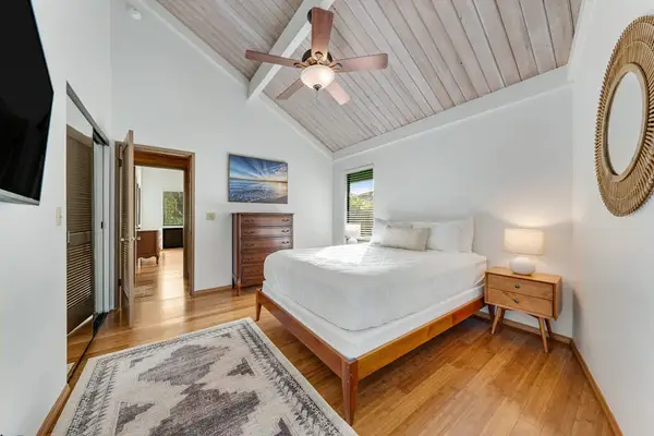 Sunlit sleeping corner blends pale linens timber floors and openness