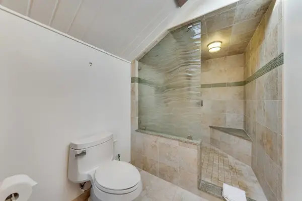 Stone tiled shower and toilet create refreshing practical bathroom retreat