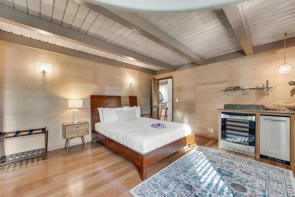Open sleeping space pairs bar seating television and lofty beams