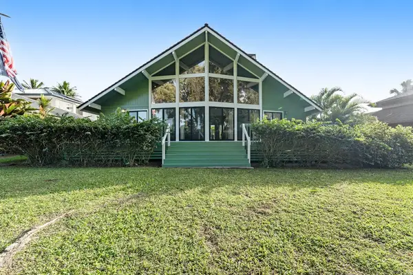 Front lawn reveals striking green façade beneath cloudless island skies
