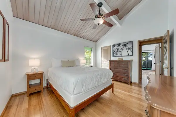 Soft bedside lamp complements crisp linens warm floors and garden