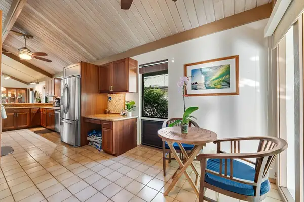 Sunlit breakfast nook connects tile floors cabinetry and garden views