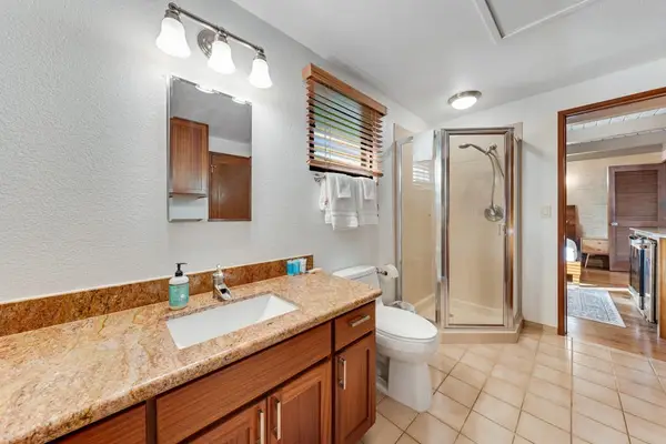 Granite vanity and glass shower create a polished refreshed retreat