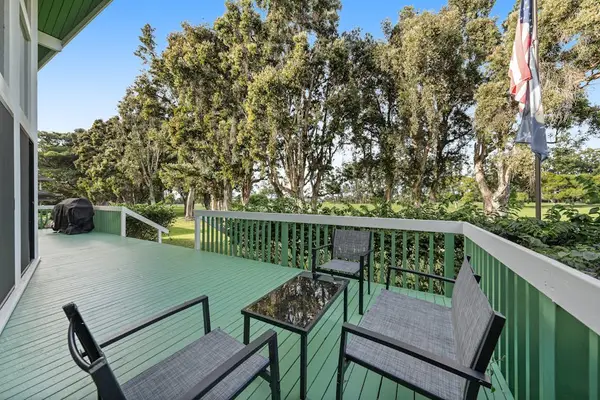 Green patio offers outdoor seating surrounded by towering tropical trees
