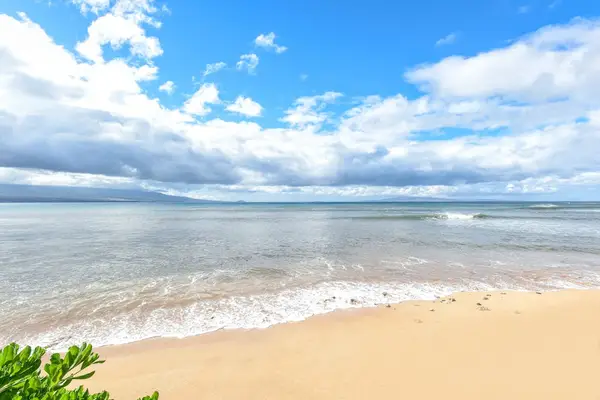 Crystal-clear turquoise waters gently wash onto pristine white sandy beaches.