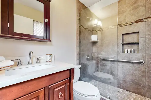 Newly update bathroom remodel with a walk in tiled shower and updated fixtures.