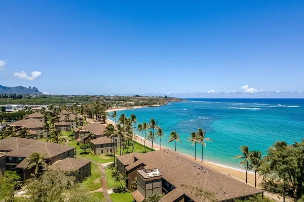 Turquoise water of the Pacific Ocean crashing on to the white sandy beaches while the palm trees sway in the breeze.