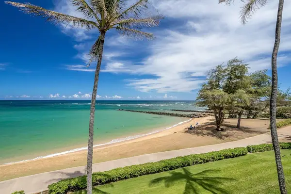 Turquoise water of the Pacific Ocean crashing on to the white sandy beaches while the palm trees sway in the breeze.
