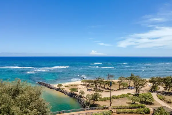 Turquoise water of the Pacific Ocean crashing on to the white sandy beaches while the palm trees sway in the breeze.
