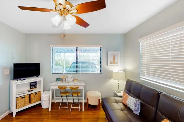 Bright living space featuring a comfortable leather sofa, media console setup, and a dedicated remote work desk station! 🛋️💻