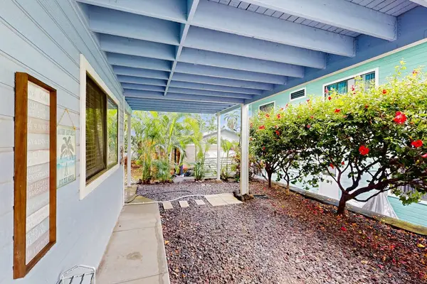 Beautiful covered patio walkway featuring a vibrant blue pergola, manicured garden hedges, and a peaceful outdoor vibe! 🌿✨