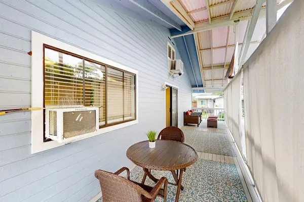 Covered balcony walkway featuring a charming outdoor bistro table, chairs, and a peaceful patio layout for guests! 🪑☀️