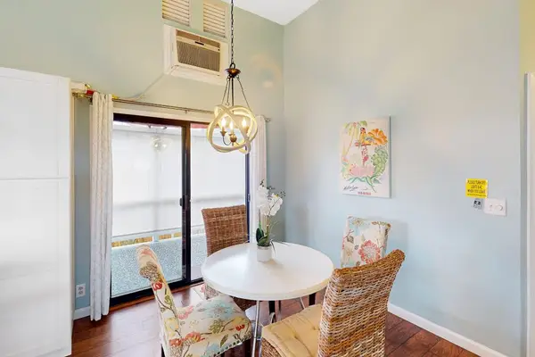 Bright dining area featuring a round table, stylish woven chairs, and large sliding doors with direct balcony access! 🍽️☀️