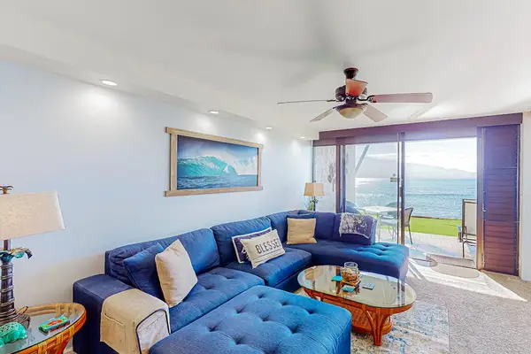 Living room with comfortable sofa and an ocean front view.  Leave the doors to the lanai open and listen to the waves crashing.