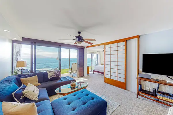 Amazingly comfortable sofa, flat screen tv and a view out that glass doors of the ocean just steps away  from you.