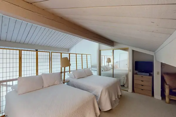 Spacious loft sleeping area offers comfort beneath charming vaulted ceilings