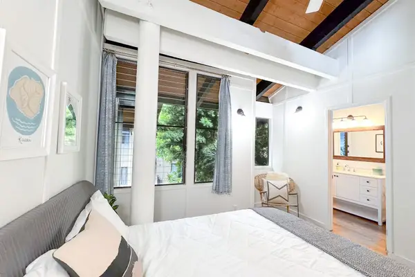 This bedroom frames plush bedding tropical windows and built in shelving