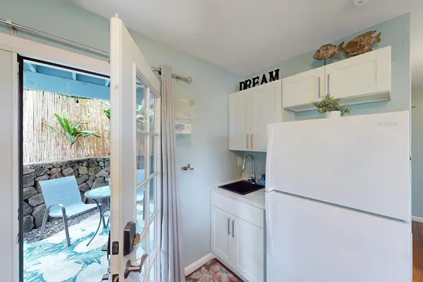Bright kitchenette layout featuring a full-size refrigerator and a wide-open door leading directly to a private patio! 🚪🍃
