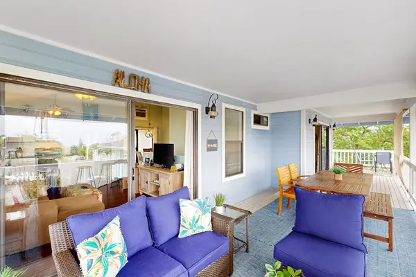 Beautiful covered balcony lounge featuring plush blue seating, tropical accent pillows, and a spacious layout for outdoor relaxation! 🛋️☀️