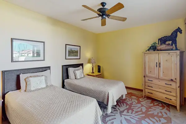 Charming Guest Bedroom with Two Twin Beds, Tropical Ceiling Fan & Wooden Armoire