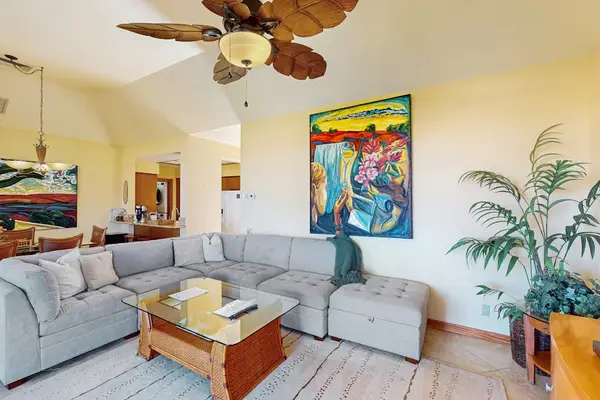 Plush Sectional Lounge with Tropical Ceiling Fan & Vibrant Artwork