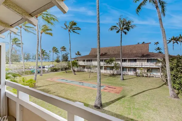 The living area seamlessly opens onto a private lanai with comfortable seating and impressive views of the mountains and surrounding landscape.