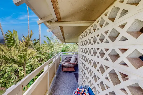 The living area seamlessly opens onto a private lanai with comfortable seating and impressive views of the mountains and surrounding landscape.