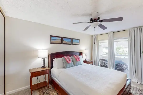 Master bedroom with king bed, flat screen tv and a ceiling fan for comfort.