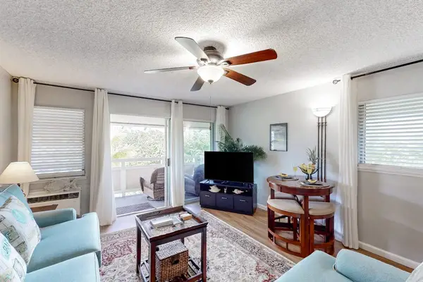 The living area seamlessly opens onto a private lanai with comfortable seating and impressive views of the mountains and surrounding landscape.