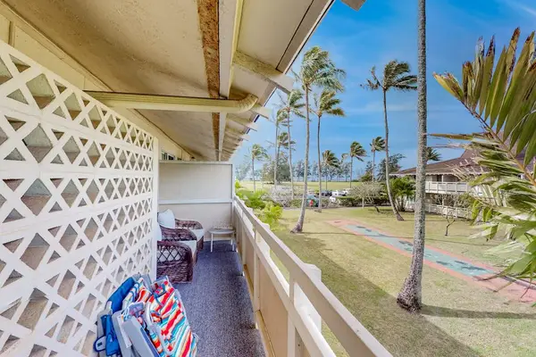 The living area seamlessly opens onto a private lanai with comfortable seating and impressive views of the mountains and surrounding landscape.