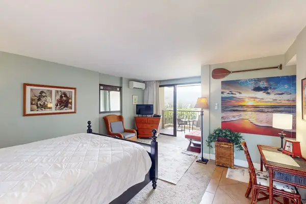 Bright studio includes comfortable bedding, dresser, artwork, and peaceful decor