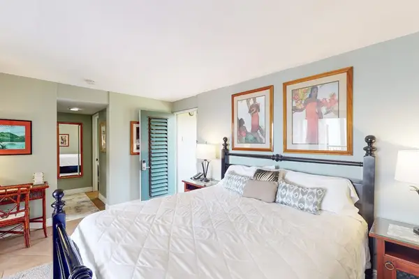 Studio offers comfortable bedding, artwork, and convenient balcony access nearby