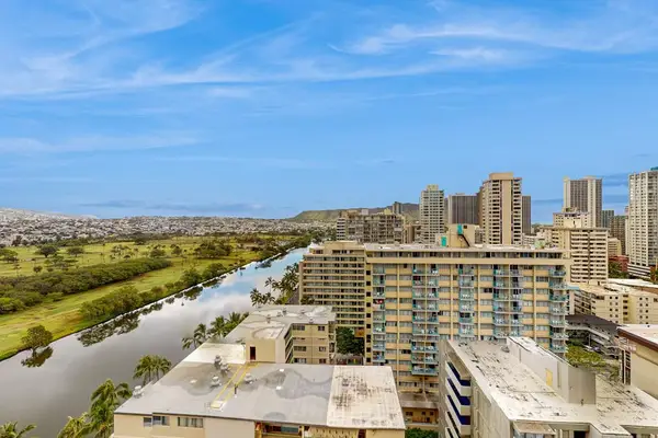 Balcony panorama overlooking Waikiki rooftops, canal, and mountain foothills