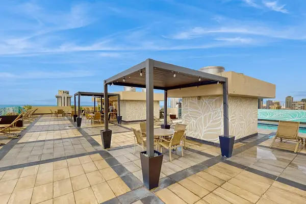 Open-air pool deck with shaded seating and skyline views