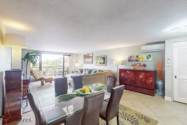 Open dining space connects kitchen island seating and tropical artwork