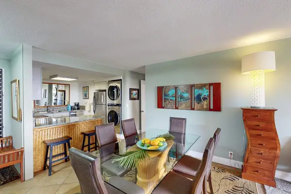 Inviting dining nook sits beside kitchen bar and tropical artwork