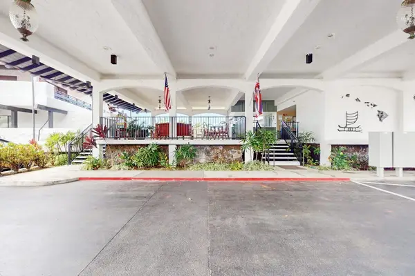 Covered entrance welcomes guests with open seating and tropical surroundings