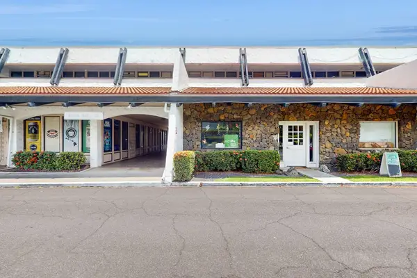 Charming stone exterior features covered walkway and landscaped grounds nearby