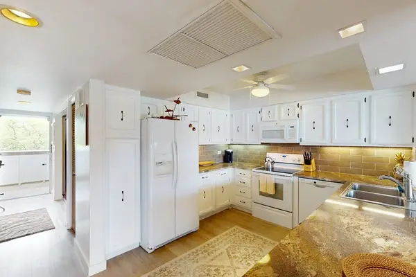 Bright Kitchen Angle Highlighting Prep Counter & Full-Sized Refrigerator