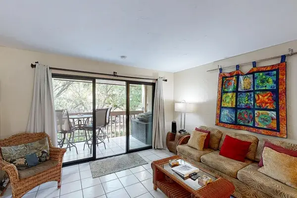 Open living room that opens up to a private outdoor balcony through large sliding glass doors