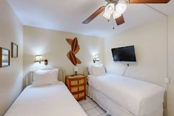 Wall mounted television overlooking 2 single beds